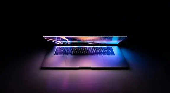 Partially open laptop with colorful lights on screen